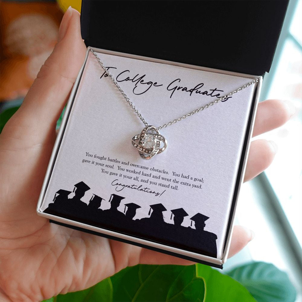 You Stand Tall love knot necklace in hand