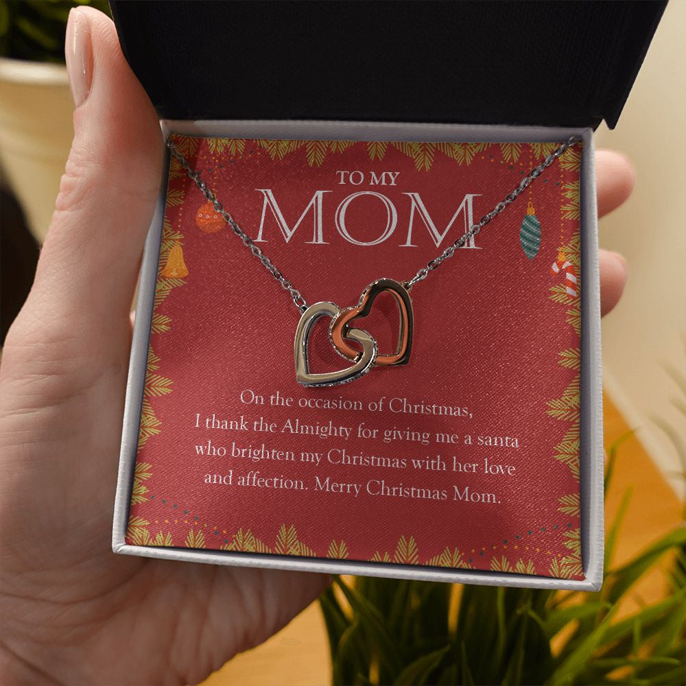 A Santa Who Brightens My Day interlocking heart necklace in hand