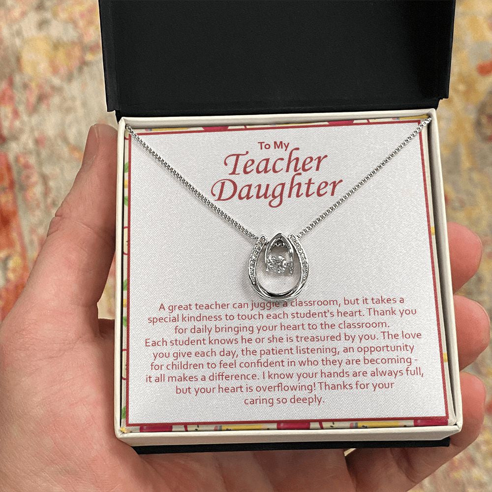 Juggle A Classroom horseshoe necklace in hand