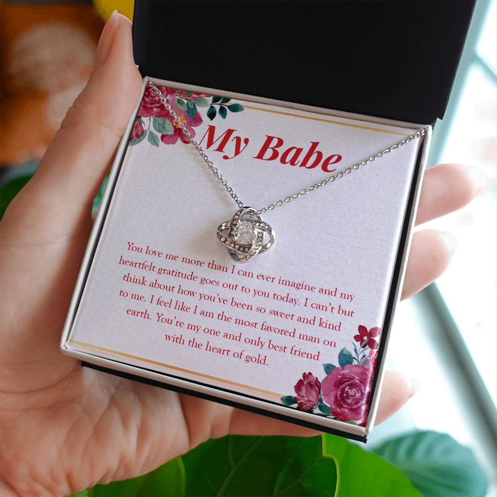 Most Favored Man On Earth love knot necklace in hand