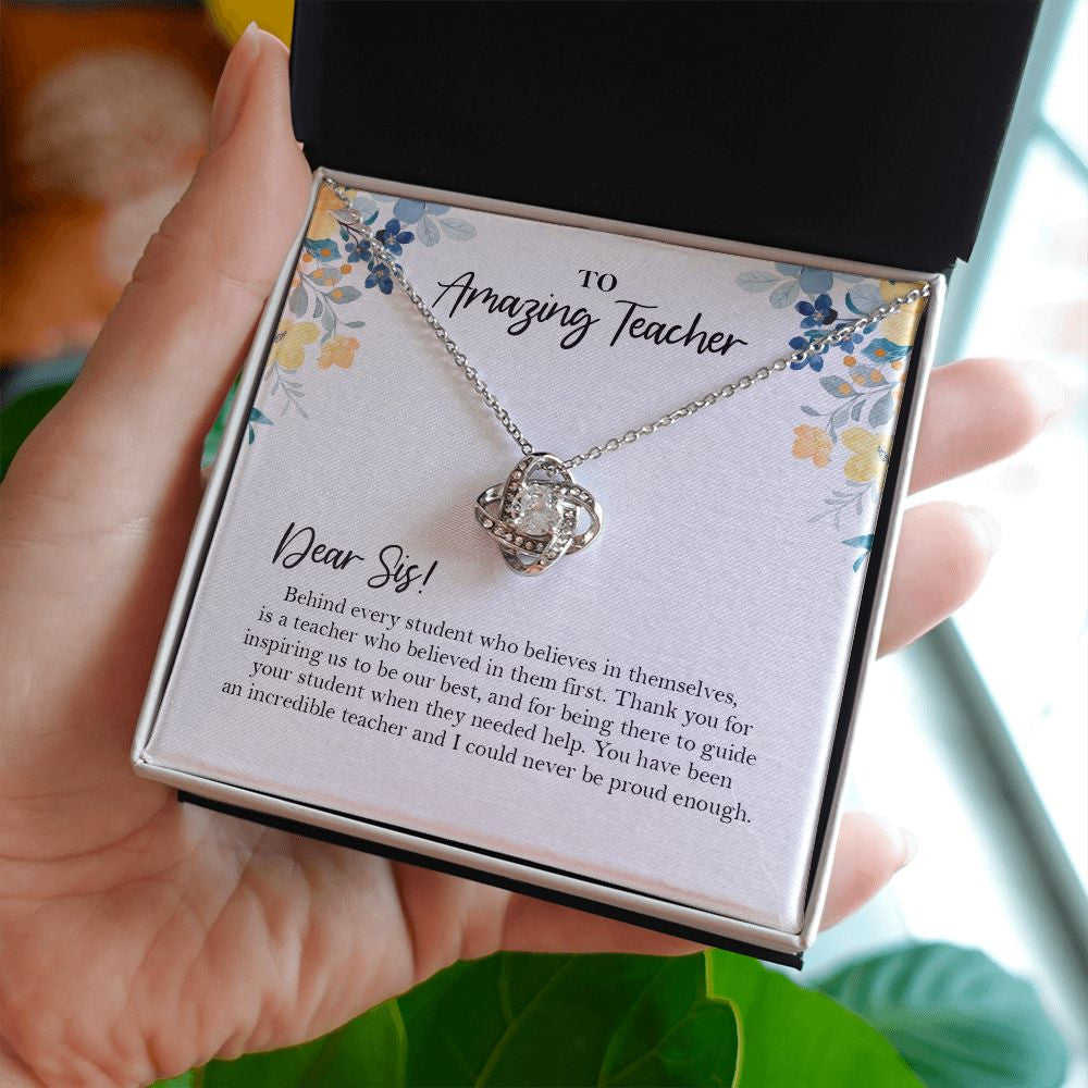 Behind Every Student love knot necklace in hand