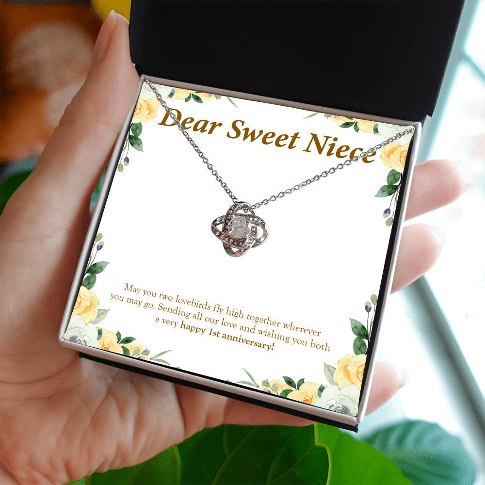 Two Lovebirds love knot necklace in hand