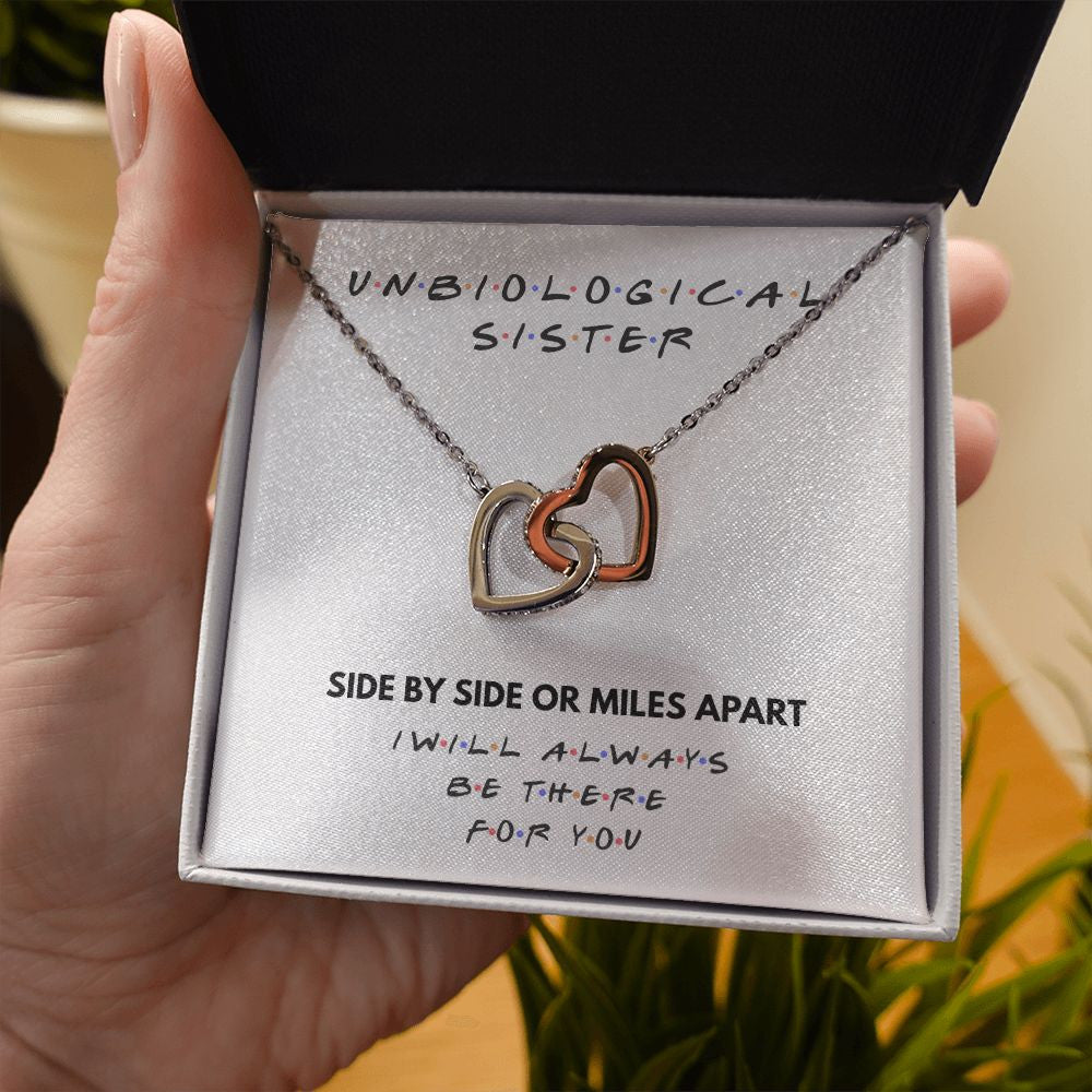 Side By Side interlocking heart necklace in hand
