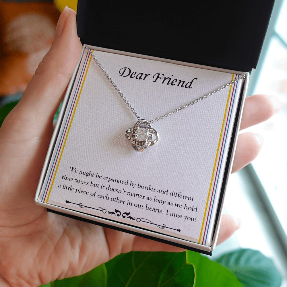 Separated By Border And Time Zone love knot necklace in hand