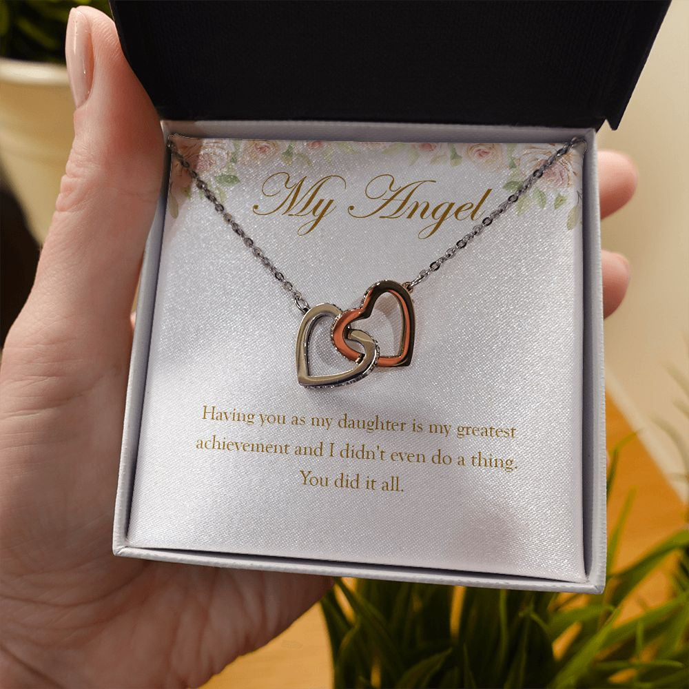 My Greatest Achievement interlocking heart necklace in hand