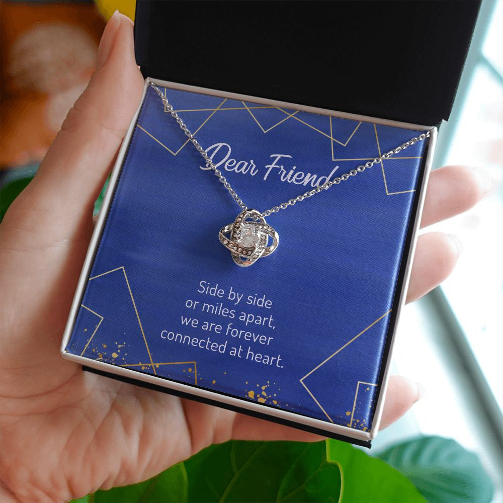Side By Side Or Miles Apart love knot necklace in hand