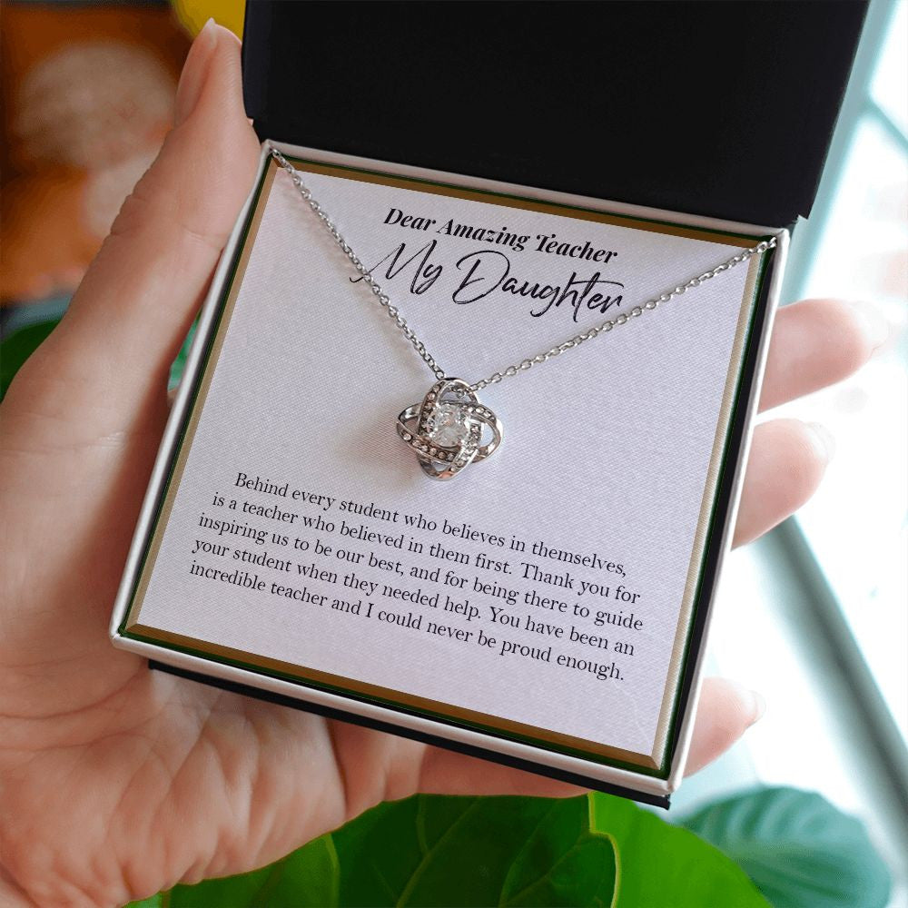 Behind Every Student love knot necklace in hand