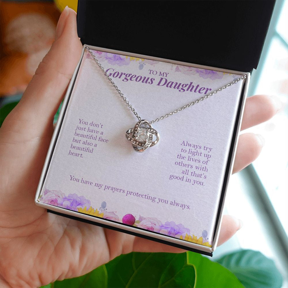 Light Up The Lives love knot necklace in hand