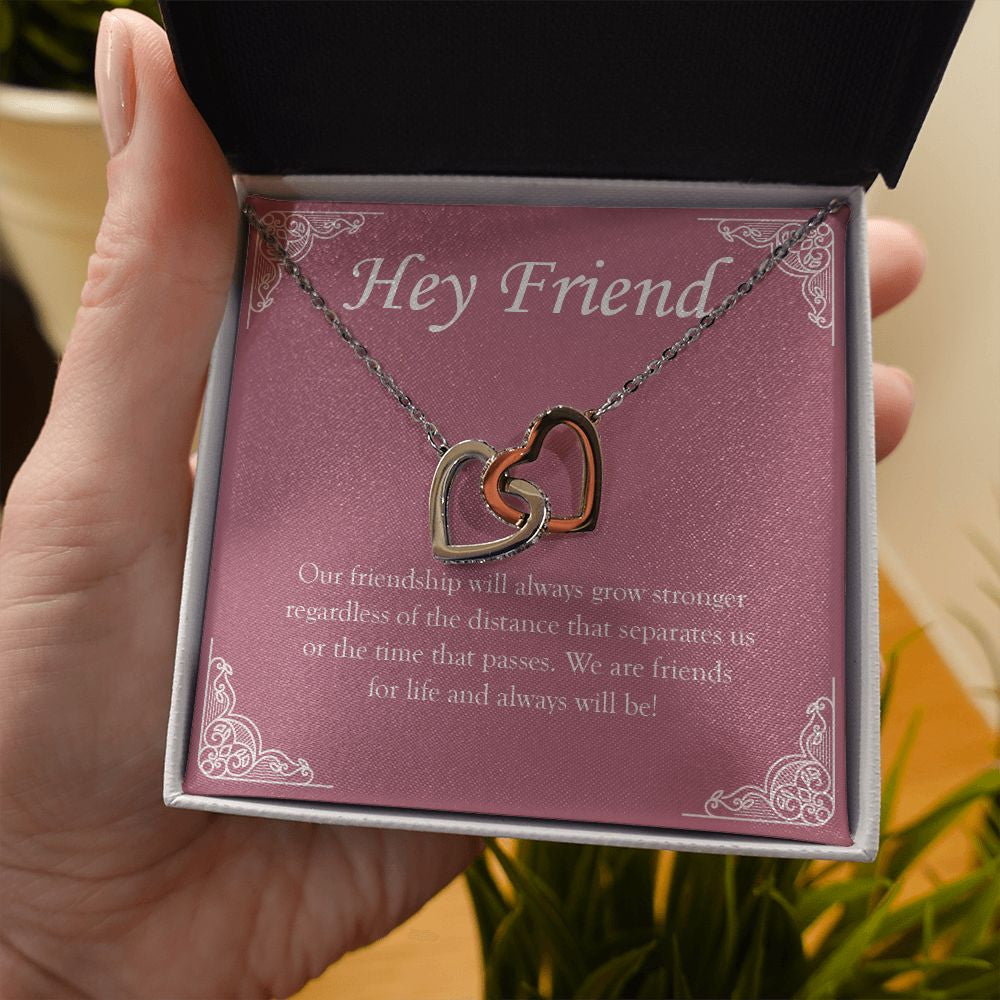 Stronger Regardless The Distance interlocking heart necklace in hand