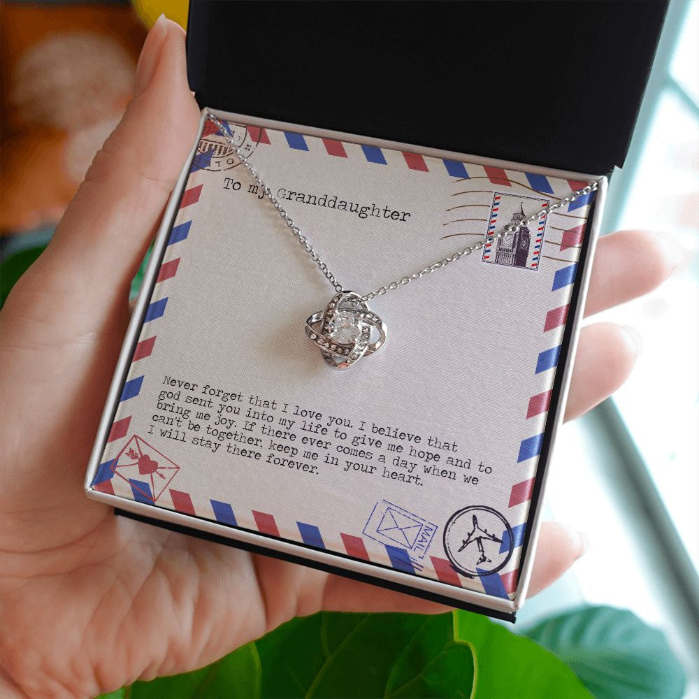 Bring Me Joy love knot necklace in hand