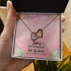 Sisters Not By Blood interlocking heart necklace in hand